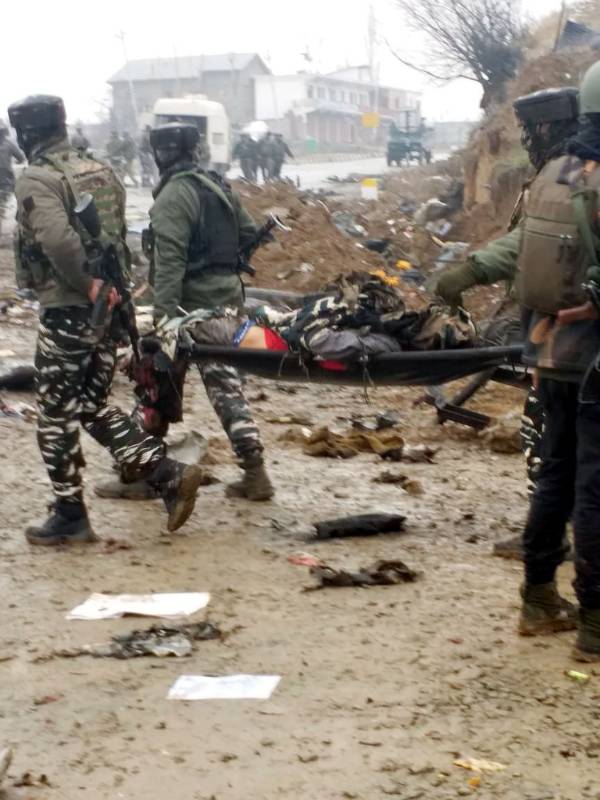 Pulwama: Security personnel takes away a victim of suicide bomb blast in Jammu and Kashmir's Pulwama district, on Feb 14, 2019. Ten Central Reserve Police Force (CRPF) troopers were killed and 15 others injured in an audacious suicide attack by militants on the Srinagar-Jammu highway. The militants detonated an improvised explosive device (IED) targeting a CRPF bus in Lethpora area, about 30 km from here, around 3.15 p.m.(Photo: IANS)