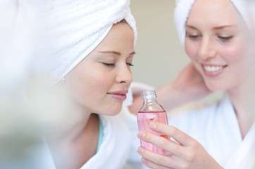 Young women in spa inhaling aromatherapy products