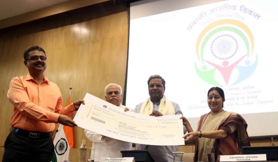 New Delhi: External Affairs Minister Sushma Swaraj and Karnataka Chief Minister Siddaramaiah felicitate Debasish Sarkar, who designed the logo of 14th Pravasi Bharatiya Divas Convention in New Delhi, on Aug 26, 2016. (Photo: IANS)