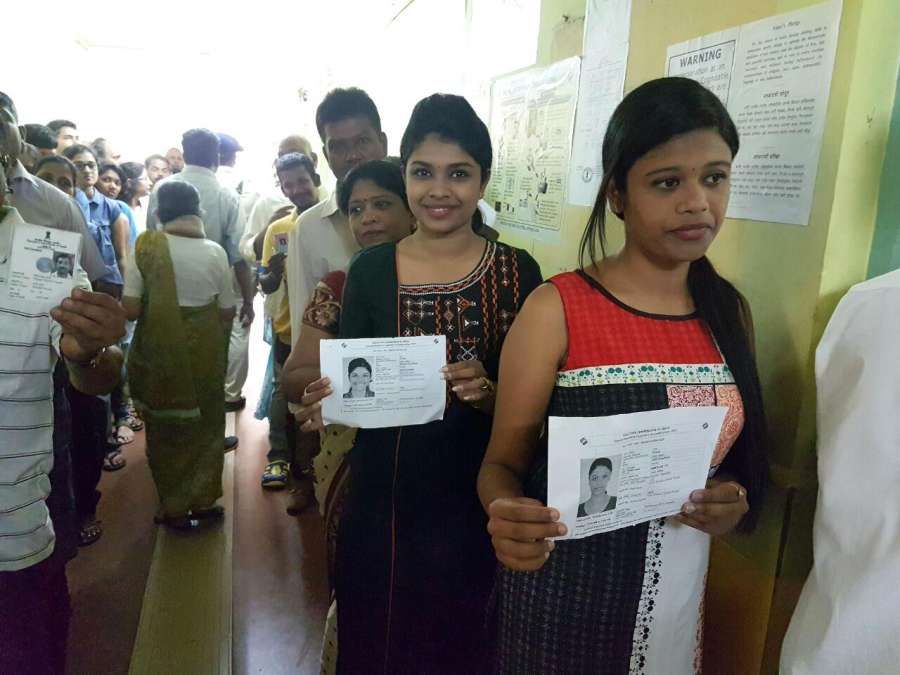 Panaji: Voters show their voter ID cards as they wait in a queue to cast their vote at a polling booth during Goa Legislative Assembly polls in Panaji, on Feb 4, 2017. (Photo: IANS) by . 
