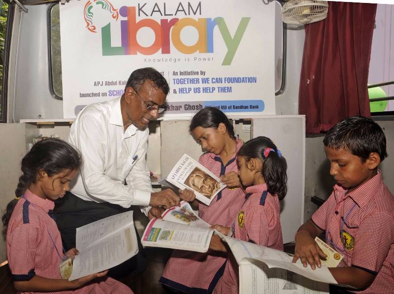 Kolkata: Bandhan Bank Managing Director Chandra Shekhar Ghosh with children on "Kalam Library on Wheels" in Kolkata, on May 12, 2016. (Photo: IANS) by . 