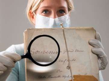 Woman with magnifying glass showing file by .