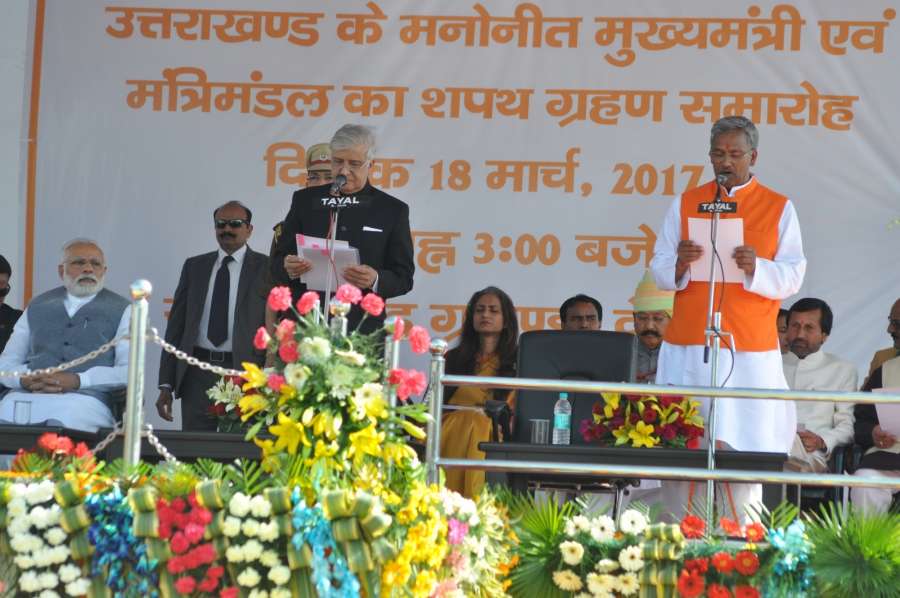 Dehradun: Uttarakhand Governor Krishan Kant Paul administer the oath to Trivendra Singh Rawat as Chief Minister of Uttarakhand during a swearing in ceremony in Dehradun, on March 18, 2017. Also seen Prime Minister Narendra Modi. (Photo: IANS) by .