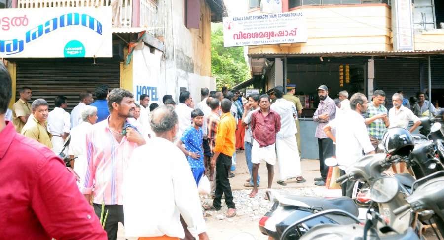 Kannur: People queue up outside a Kerala State Beverages (M&M) Corporation Ltd outlet in Kannur to buy liquor after the Supreme Court banned liquor shops within 500 metres on either side of the national and state highways in a bid to curb accidents caused by drunken driving; on April 3, 2017. (Photo: IANS) by . 