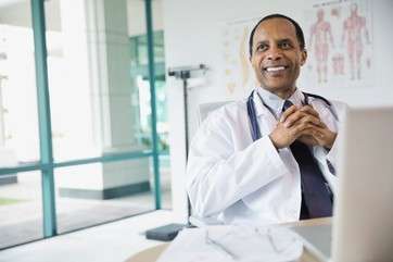 Portrait of confident male doctor smiling by .