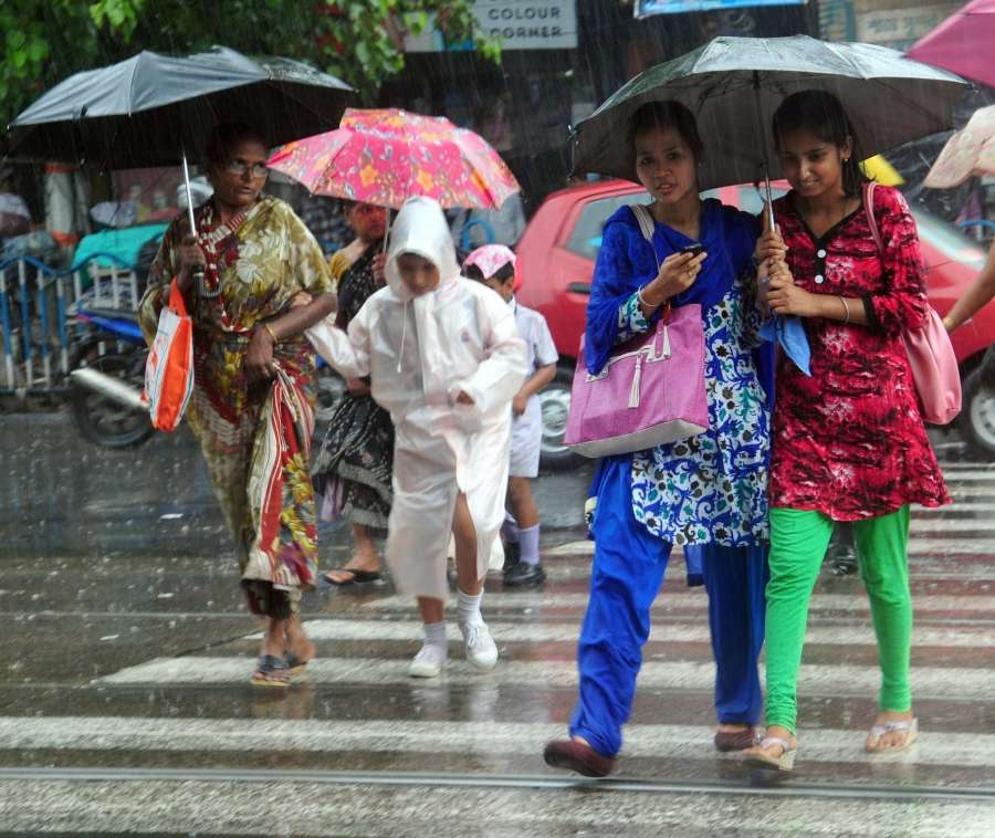 Kolkata: People use umbrellas to protect themselves from rains in Kolkata on June 24, 2017. (Photo: Kuntal Chakrabarty/IANS) by . 