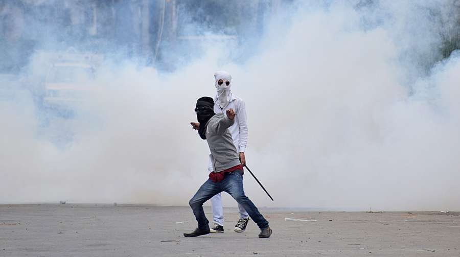 Srinagar: A protester pelts stones on security personnel after Eid al-Adha prayers in Srinagar, on Sept 2, 2017. (Photo: IANS) by .