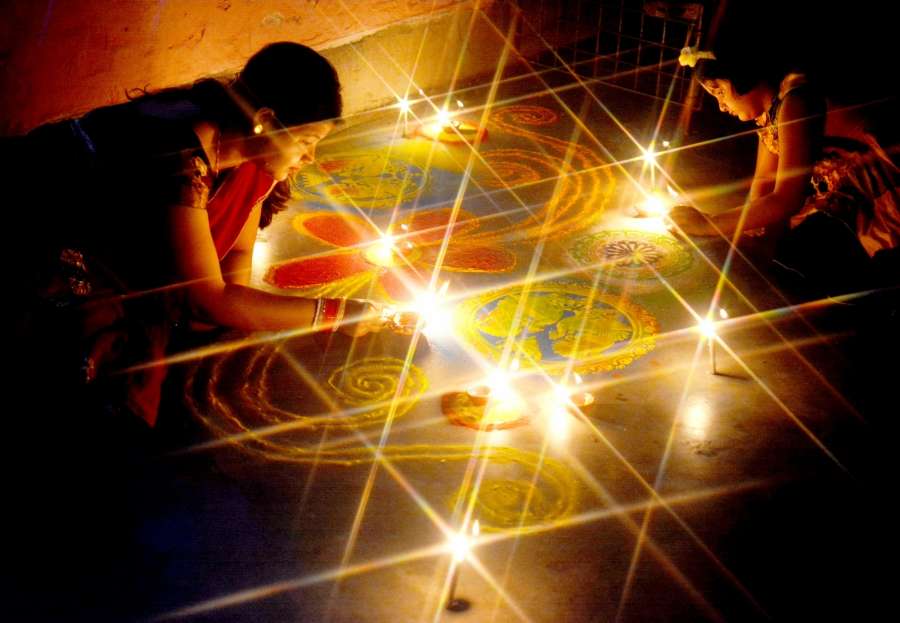 Kolkata: A woman and her child busy making 'Rangoli' on the eve of Diwali in Kolkata, on Oct 18, 2017. (Photo: Kuntal Chakrabarty/IANS) by .