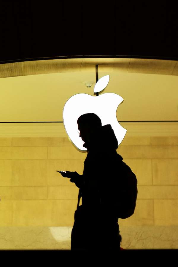 A man checks his phone at the Apple store.