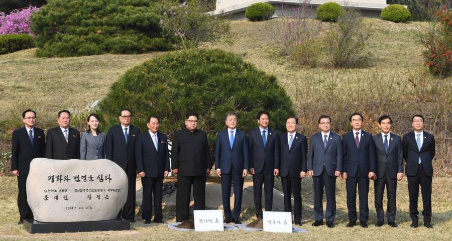 Panmunjom: South Korean President Moon Jae-in (7th from L), his North Korean counterpart Kim Jong-un (6th from L) and their entourages pose after a tree-planting ceremony to mark their historic talks at the truce village of Panmunjom on April 27, 2018. The phrase on the commemorative stone reads, "(We) Plant Peace and Prosperity. President Moon Jae-in of the Republic of Korea. Chairman of the State Affairs Commission Kim Jong-un of the Democratic People's Republic of Korea."(Yonhap/IANS) by . 