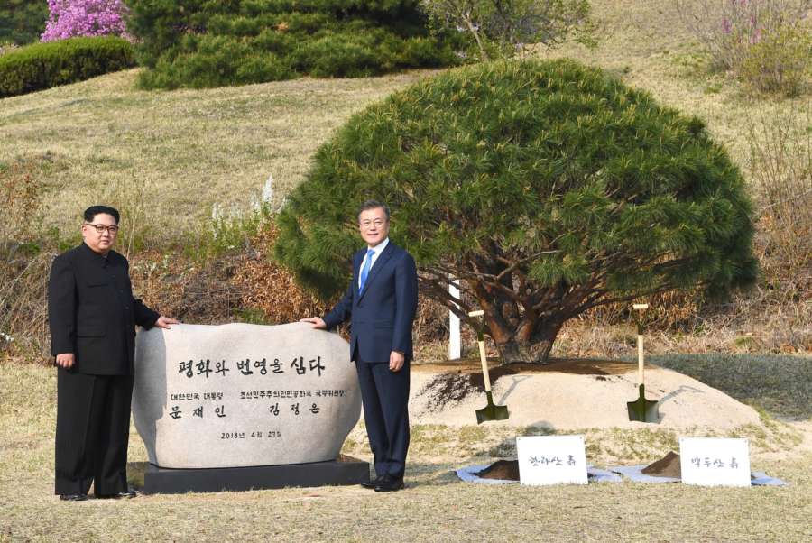 Panmunjom: South Korean President Moon Jae-in (R) and his North Korean counterpart Kim Jong-un pose beside a commemorative cornerstone after a tree-planting ceremony to mark their historic talks at the truce village of Panmunjom on April 27, 2018, in this photo provided by Yonhap News TV. The phrase on the stone reads, "(We) Plant Peace and Prosperity. President Moon Jae-in of the Republic of Korea. Chairman of the State Affairs Commission Kim Jong-un of the Democratic People's Republic of Korea." (Yonhap/IANS) by . 