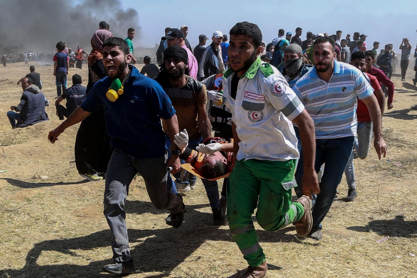 GAZA, May 14, 2018 (Xinhua) -- Palestinian medics and protesters carry an injured man during clashes with Israeli troops near the Gaza-Israel border, east of Gaza City, on May 14, 2018. More than 40 Palestinians, including children, were killed Monday in a day of violent clashes with Israeli forces on Israel's southern border with Gaza, according to the Gaza health ministry. (Xinhua/Wissam Nassar/IANS) by . 