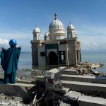 PALU, Oct. 8, 2018 (Xinhua) -- A woman stands near the debris of a damaged mosque on Talise beach in Palu, Central Sulawesi, Indonesia. Death toll from multiple powerful quakes and an ensuing tsunami striking Central Sulawesi province of Indonesia on September 28 jumped to 1,948 on Monday and more than 5,000 others went missing, according to a disaster agency official here. (Xinhua/Agung Kuncahya B/IANS) by .