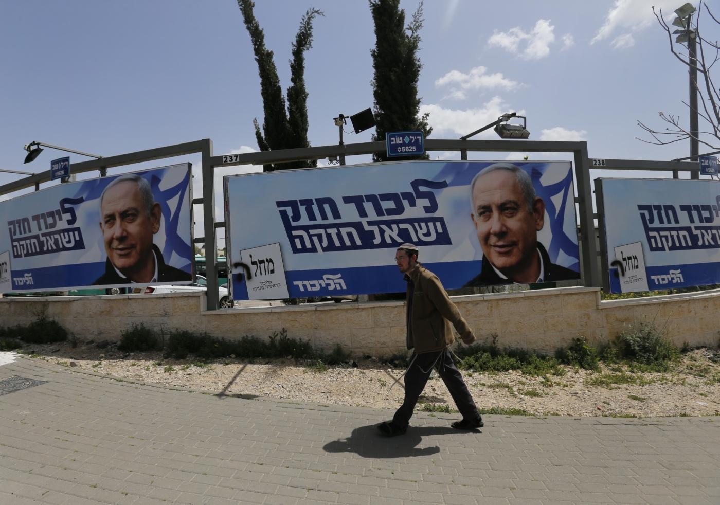 JERUSALEM, April 8, 2019 (Xinhua) -- A man walks past a Likud Party election campaign poster depicting Israeli Prime Minister Benjamin Netanyahu in Jerusalem, on April 7, 2019. (Xinhua/Muammar Awad/IANS) by .