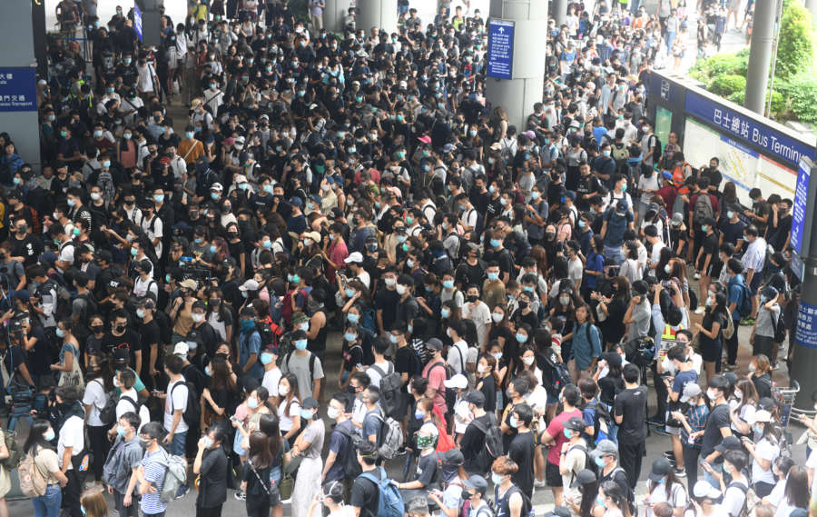 HONG KONG, Sept. 1, 2019 (Xinhua) -- Radical protesters block the exit to bus terminal at Hong Kong International Airport in south China's Hong Kong, Sept. 1, 2019. A large group of radical protesters charged security cordon lines, damaged facilities, and disrupted the operations of the Hong Kong International Airport on Sunday. n Protesters started gathering at the bus stops of the airport terminal at 1:00 p.m. local time. Around 2:00 p.m., the radical protesters started to charge water-filled barriers, pointed laser beams at the airport authority staff, and blocked roads with trolleys and mills barriers. n They also hurled objects at police officers and airport authority staff. Some radical protesters used iron bars to smash the doors of airport facilities. n At around 3:30 p.m., the police said they would soon conduct a dispersal operation and asked all protesters to leave and stop their illegal acts immediately. n As the protesters left the airport, some black-clad men built barricades to keep police away and paralyze the traffic surrounding the airport. (Xinhua/IANS) by Lu Hanxin.