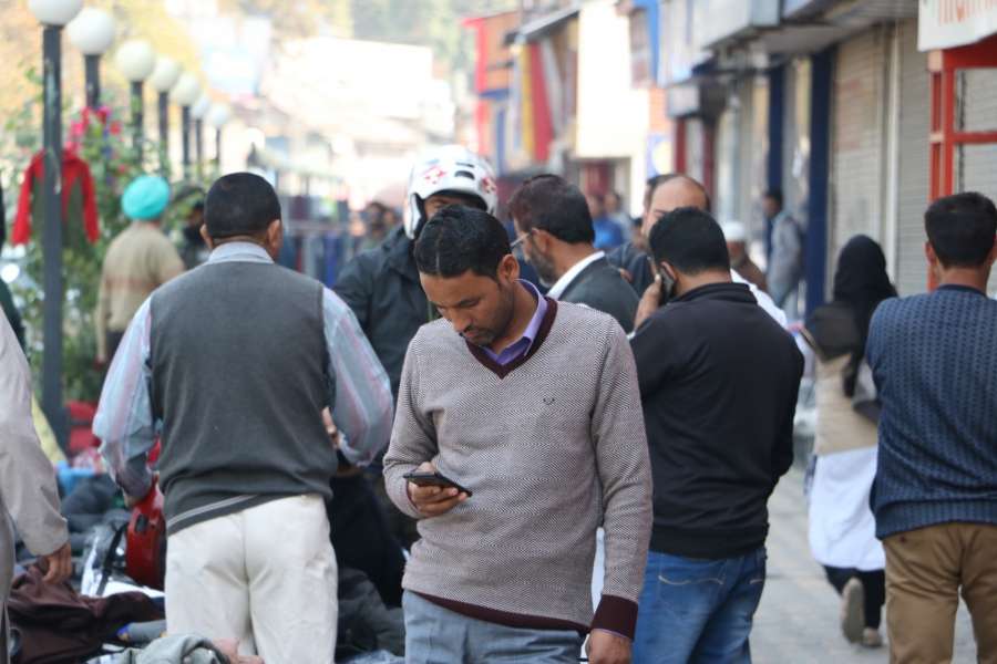Srinagar: People busy on their mobile phones as services of all post paid mobile phones were resumed across the Kashmir Valley after it was suspended on the intervening night of August 4 and August 5 ahead of the scrapping of Article 370; in Srinagar on Oct 14, 2019. (Photo: IANS) by . 