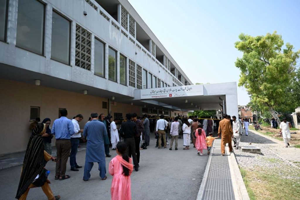People gather at the entrance of Pakistan Institute of Medical Sciences (PIMS)