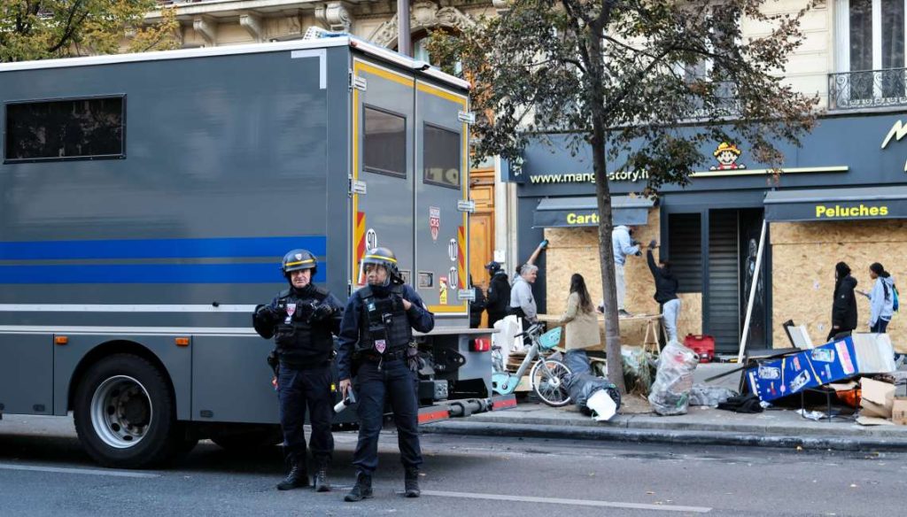 Paris: Law enforcement officers stand guard outside a shop in Paris, France, Oct. 18, 2026. French President Emmanuel Macron on Sunday vowed legal action against those responsible for violence during protests across the country on Saturday. (Xinhua via IANS)