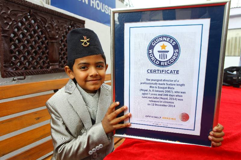 Nepalese eight-year-old kid Saugat Bista (L, front) shows the certificate of Guinness World Records for World's Youngest Director in Kathmandu, Nepal, Feb. 20, 2015. Bista had broken the record of Indian Kid Kishan Shrikanth who directed a feature film at the age of 9 by directing a movie "Love you Baba" at an age of 7 years 340 days