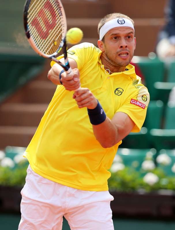 Gilles Muller of Luxembourg hits a return during the men's singles second round match against Novak Djokovic of Serbia at 2015 French Open tennis tournament at Roland Garros, in Paris, France on May 28, 2015