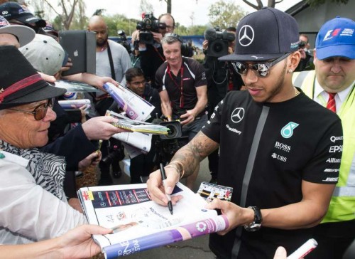 Lewis Hamilton signs autographs for his fans after the race.