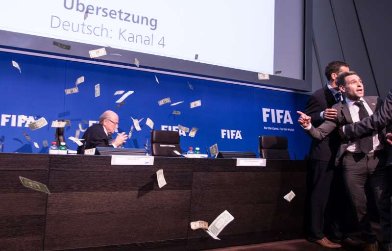 British comedian known as Lee Nelson (R) gestures after he throws banknotes in front of FIFA President Sepp Blatter (L) at a news conference after the Extraordinary FIFA Executive Committee Meeting at the FIFA headquarters in Zurich, Switzerland