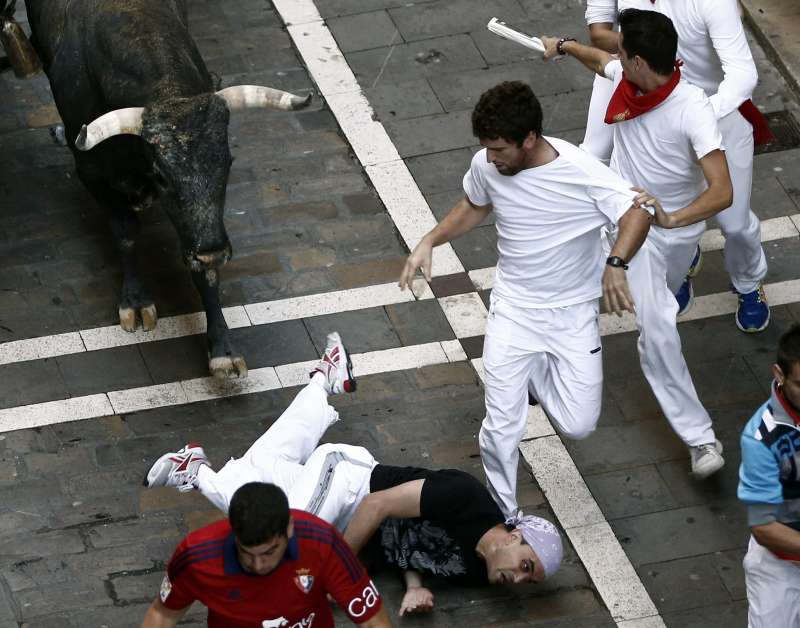 Several runners or 'mozos' are chased by bulls from Miura ranch during the last bullrun of Sanfermines 2015 in Pamplona, northern Spain. The festivities will end with thousands people signing the traditional 'pobre de mi' (poor me) in City Hall square this night.