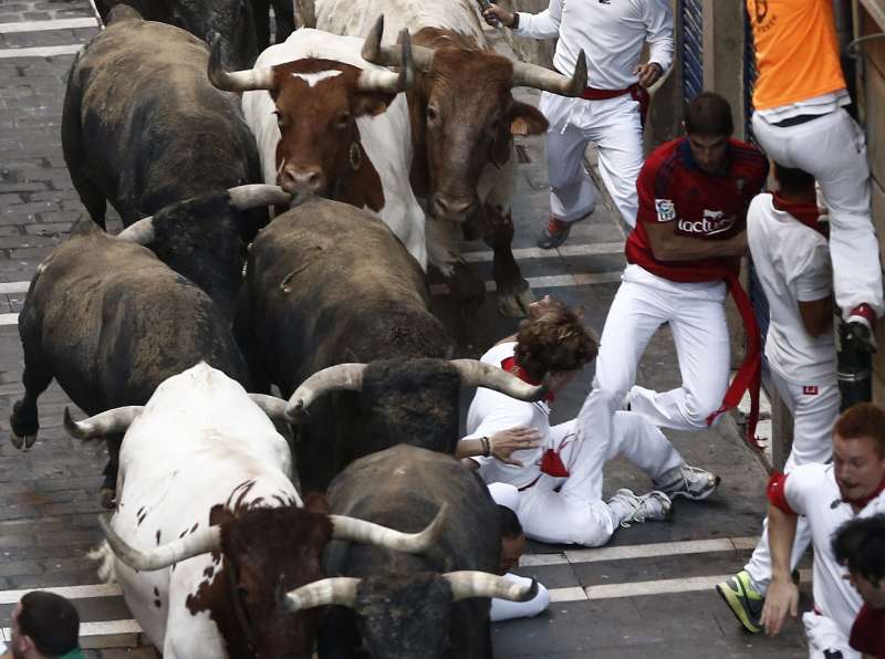 Several runners or 'mozos' are chased by bulls from Miura ranch during the last bullrun of Sanfermines 2015 in Pamplona, northern Spain. The festivities will end with thousands people signing the traditional 'pobre de mi' (poor me) in City Hall square this night.