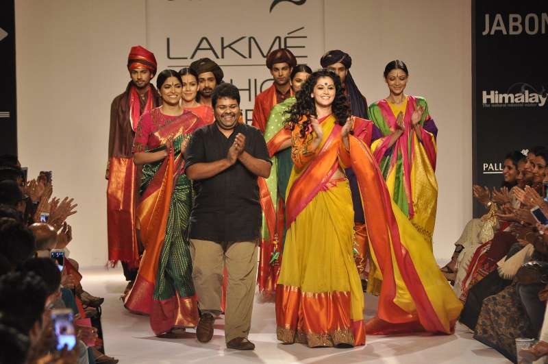 Fashion designer Gaurang Shah walks the ramp with actor Taapsee Pannu during the Lakme Fashion Week (LFW) Winter/ Festive 2014, in Mumbai, on Aug. 22, 2014. (Photo: IANS)